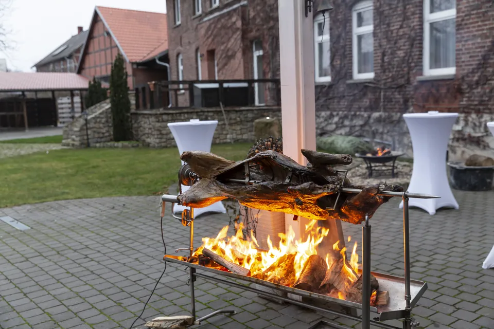 Spießbraten über offenem Feuer im Innenhof