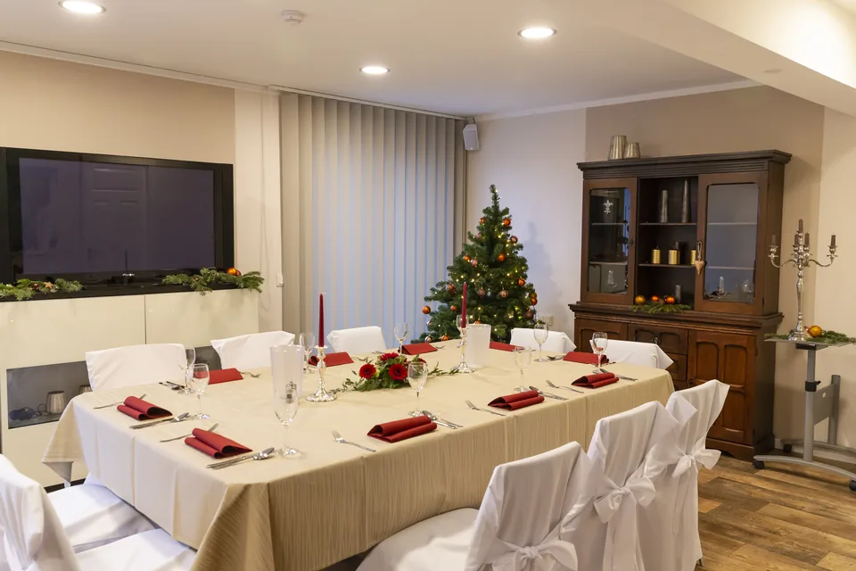 Festlich eingedeckte Tafel mit weißen Hussen