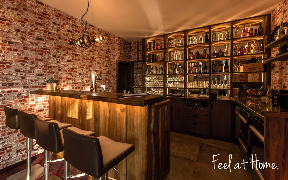 Bar mit beleuchtetem Regal und Barhockern