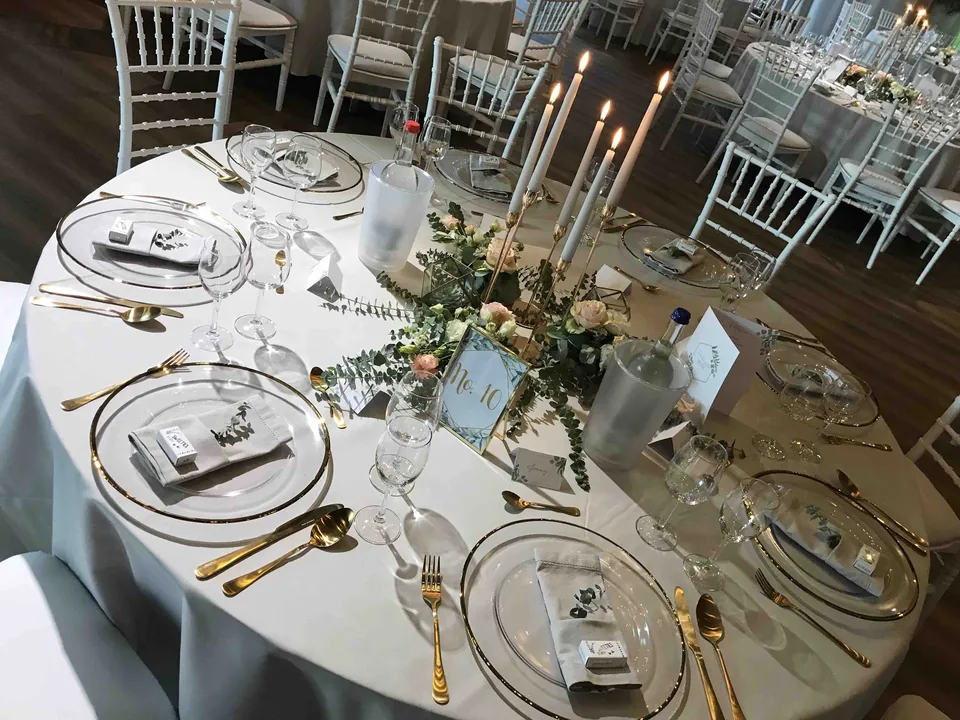 Runde Tafel mit Goldbesteck, Kerzen und Tischnummer