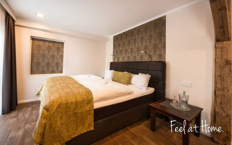 Komfort Doppelzimmer mit Boxspringbett und goldener Tagesdecke